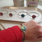 Silver colored stainless  bracelet with a round marble of green and sage gem on the center