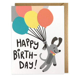 A white card with text "HAPPY BIRTHDAY!" and an image of a cartoon grey dog holding colorful balloons.