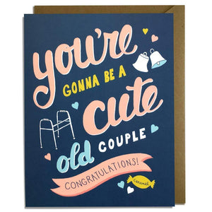 A navy colored card with pink text: "YOU'RE GONNA BE A CUTE OLD COUPLE. CONGRATULATIONS!" Comes with a brown envelope.