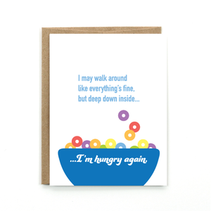 A white card with a text: "I MAY WALK AROUND LIKE EVERYTHING'S FINE. BUT DEEP DOWN INSIDE...I'M HUNGRY AGAIN" and an illustration of a blue bowl of cereal. Comes with a brown envelope.