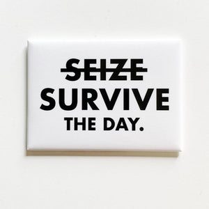 A white square magnet with text: "(SEIZE crossed out) SURVIVE THE DAY."